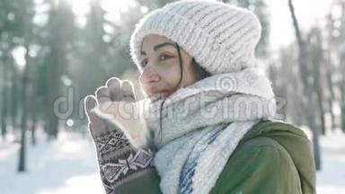 穿着羊毛帽、戴着长长的<strong>暖</strong>围巾的美丽微笑的女子在雪地<strong>冬季</strong>公园的模糊的极端特写镜头